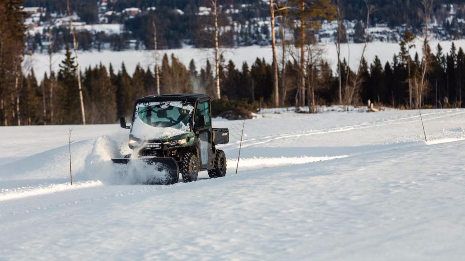 Can-Am Traxter mönkijä hytillä ja lumilevyllä lumitöissä