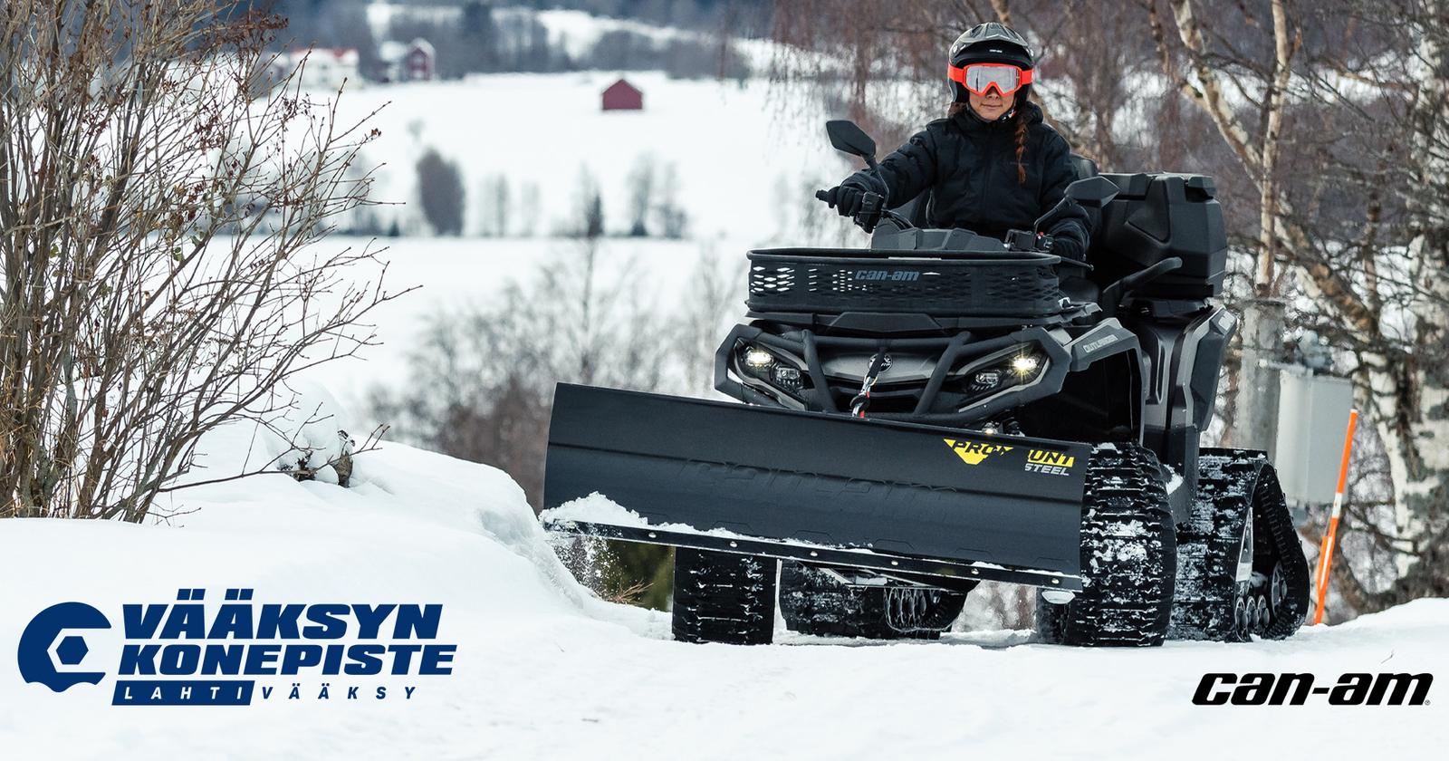 Can-Am Outlander mönkijä puskulevyllä lunta työntämässä metsässä